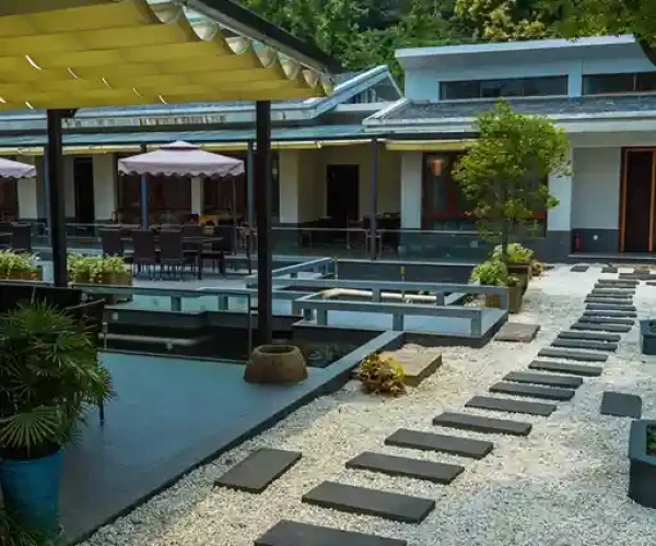 Serene Courtyard with Stone Pathway and Outdoor Seating Beautiful courtyard with a stone pathway, potted plants, and outdoor seating area.